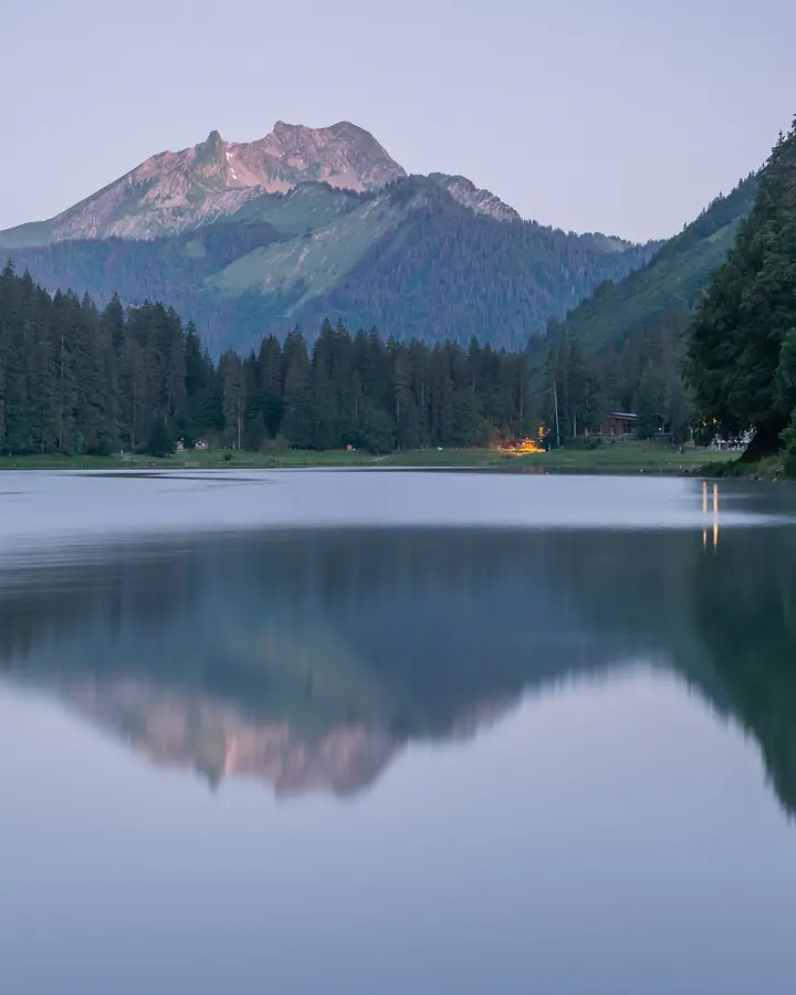 Bergsee am frühen Morgen, der Gipfel spiegelt sich im ruhigen Wasser